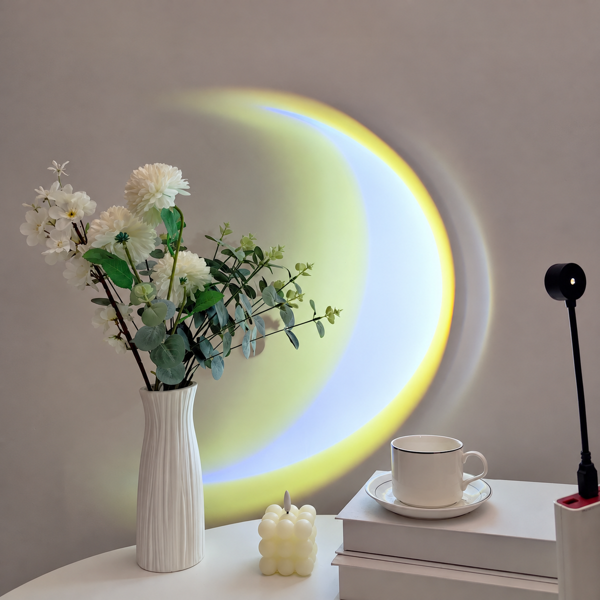 Gulvitt månformat sken från lampa på vägg bredvid en vas med blommor