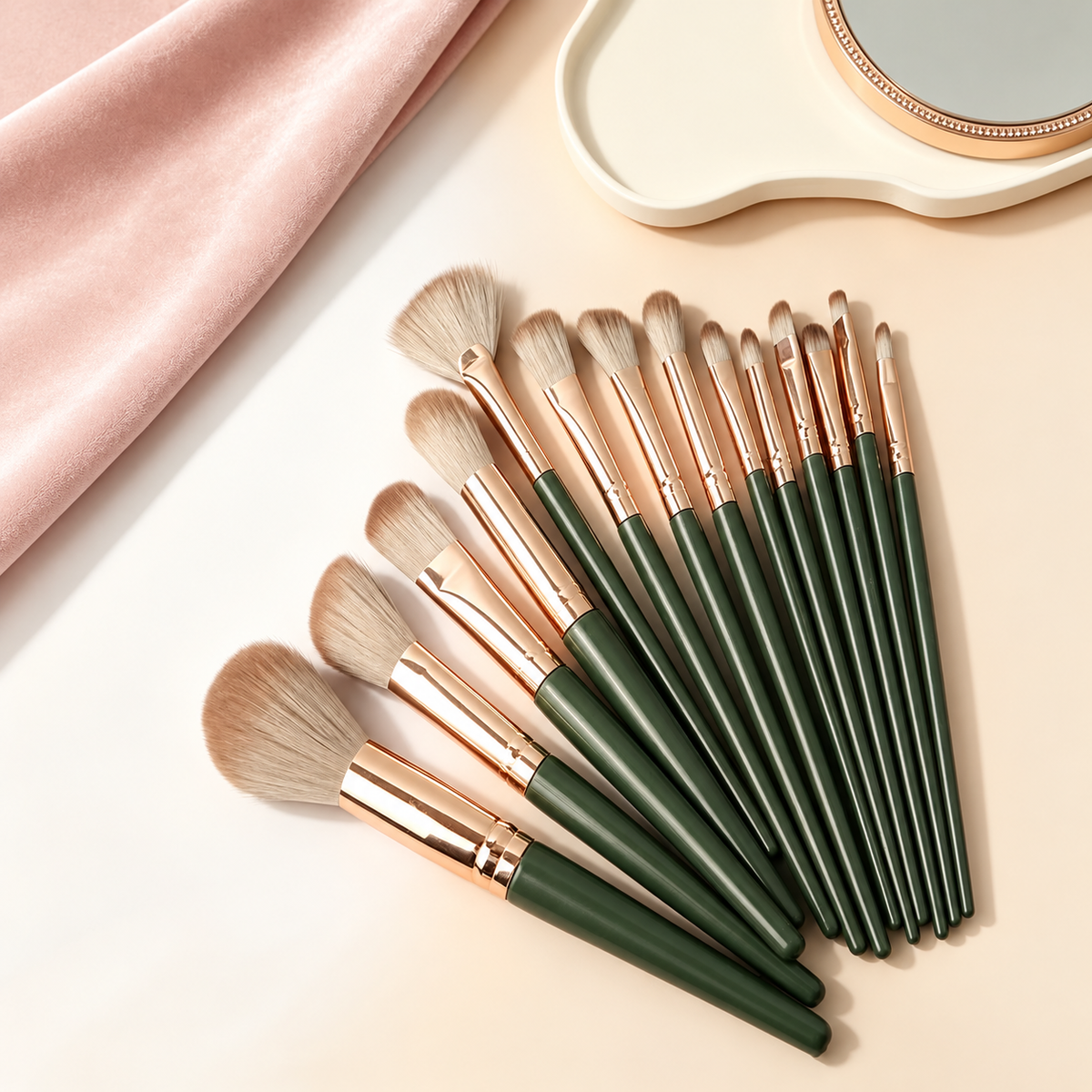 Makeupborstar i mörkgrönt och koppar utlagda som en solfjäder på beige bakgrund